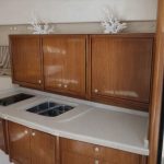 Kompakt pentry i en idrottsförening med träskåp och modern köksutrustning.