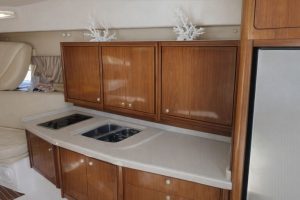 Kompakt pentry i en idrottsförening med träskåp och modern köksutrustning.